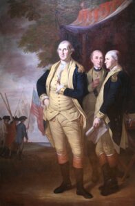 An oil portrait of General George Washington, who stands in the center wearing a blue and yellow army uniform. Behind his left shoulder stands the Marquis de Lafayette and Tench Tilghman, similarly dressed. In the background several soldiers march with rifles and a flag of the American colonies.